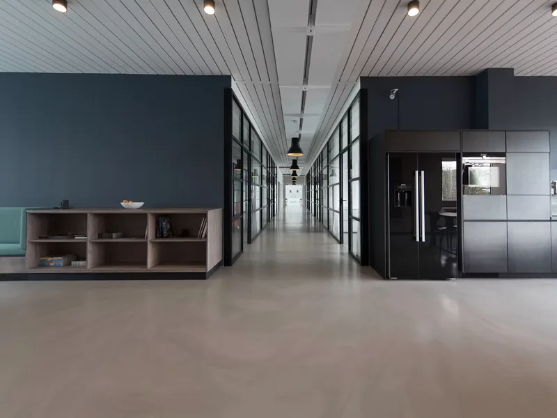 Open-plan corporate office workspace with clean partition screens and lighting